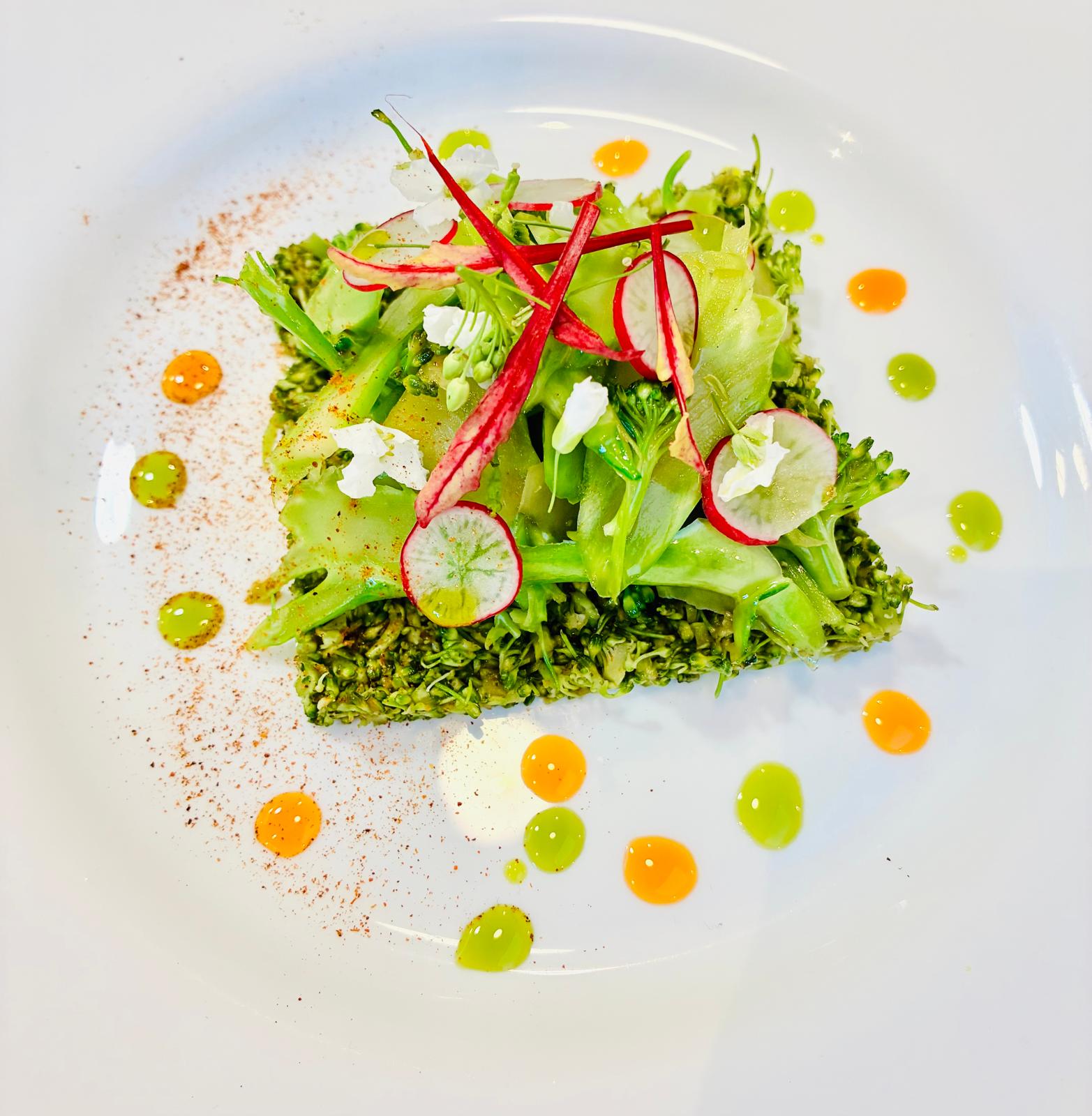 Création végétale colorée et délicate dressée dans une grande assiette blanche